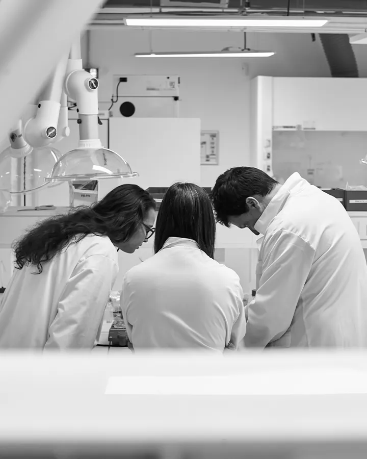 Trois employés UGIEL travaillant ensemble dans un laboratoire, représentant les carrières chez UGIEL.