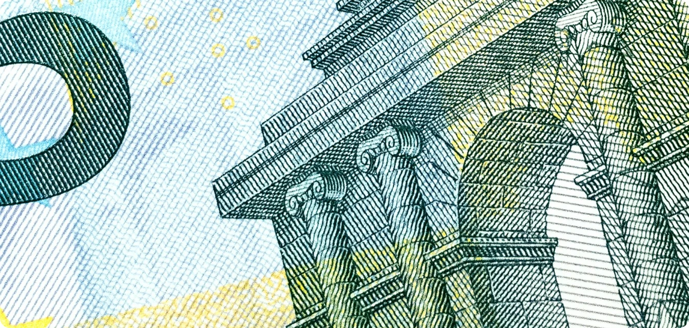 Gros plan sur un billet de banque montrant des colonnes et une arche architecturale.